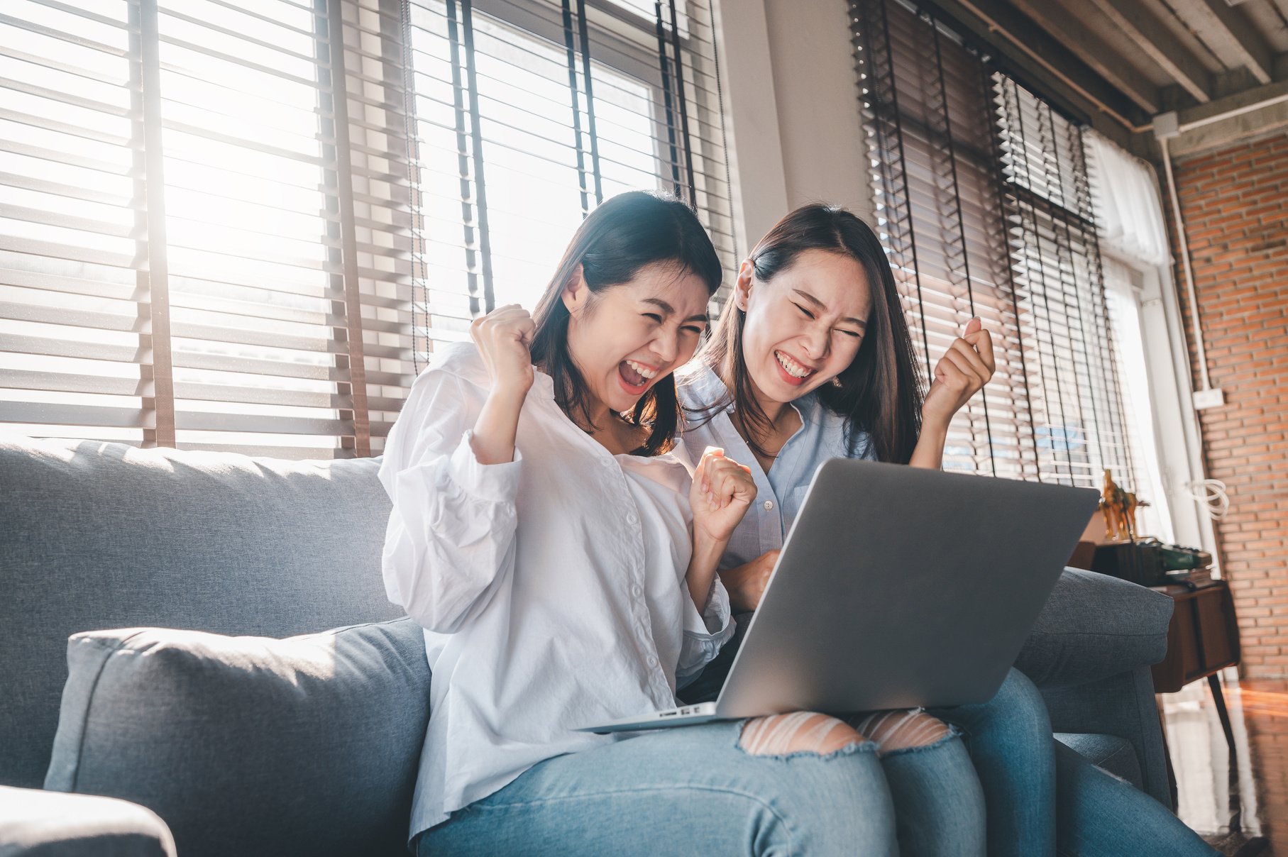 Happy Best Friends Using Laptop at Home